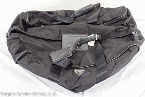 PRADA BLACK DUFFEL TRAVEL BAG: Black nylon and leather / Measurements: Approx: 14"H x 26"W 13"D / Condition: Appears to never have been used / leather tag on one zipper is missingDISCLAIMER: ****WHILE THE DESIGNER ITEMS IN OUR
