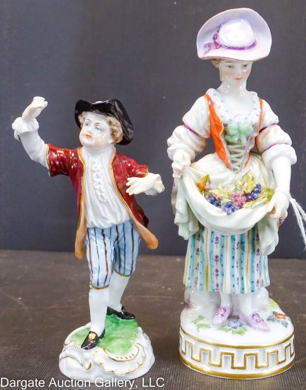 2 GERMAN PORCELAIN FIGURINES MEISSEN & DRESDEN: Includes: -- Meissen - by Michel Victor Acier, circa 1800's / crossed sword mark / woman holding grapes in her apron. - 7"H--Dresden boy holding his hand up in the air - blue Dresden mark on base - 5.