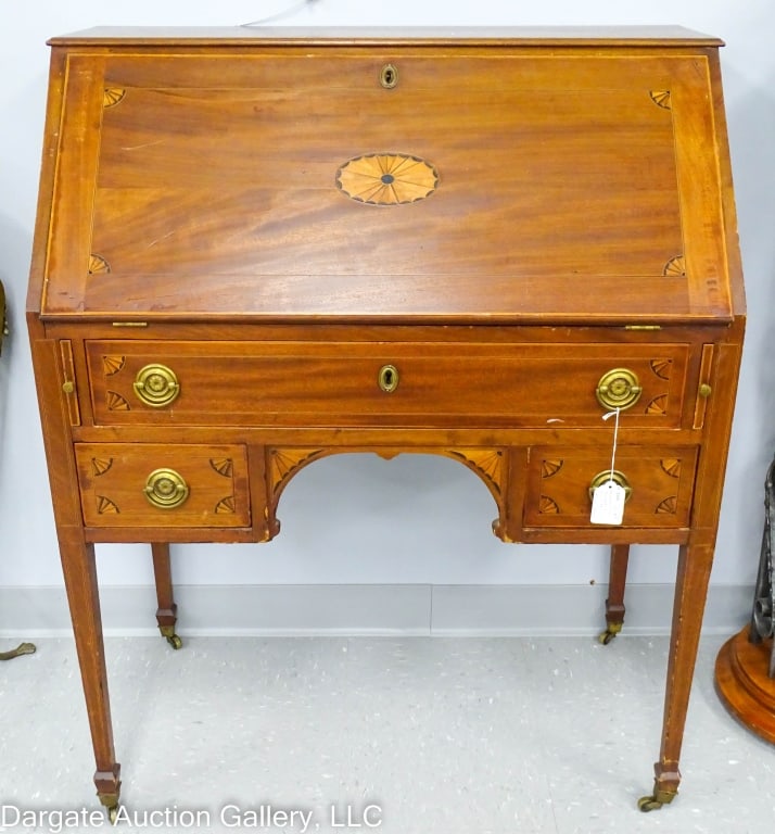 HEPPLEWHITE TRANSITION MAHOGANY DROP FRONT DESK: Mahogany drop front lady's writing desk, string inlay with corner fans and a central medallion, original hardware and brass castors. Interior has Pidgeon hole and drawers / Measures: 40.25"H x 32.75"W