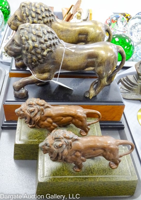 TWO PAIRS CAST STANDING LION BOOKENDS: Including a pair of cast iron patinated bronze standing lions on green patinated plinths with a pair of bronze standing lions on painted wooden bases by decorated crafts, inc. The largest set is 9" x