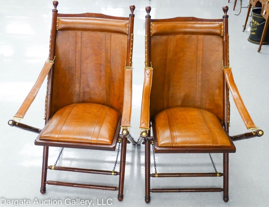 PAIR MODERN PALECEK CAMPAIGN CHAIRS: A pair of modern wood and leather Palecek campaign folding chairs. Stitched and padded leather seat and backs, brass trim tacks and end caps. Bamboo turned wooden legs and stretchers. / Measures: 41.5