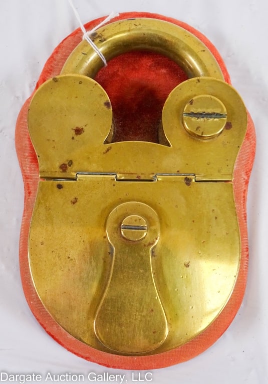 BRASS PADLOCK INKWELL, HOWELL JAMES LONDON: Unusual Victorian antique ink well in the shape of a padlock. Opens to reveal inkwell. Marked Howell, James. Regent St. London. Inkwell attached to velvet covered wooden base. Glass insert looks to be