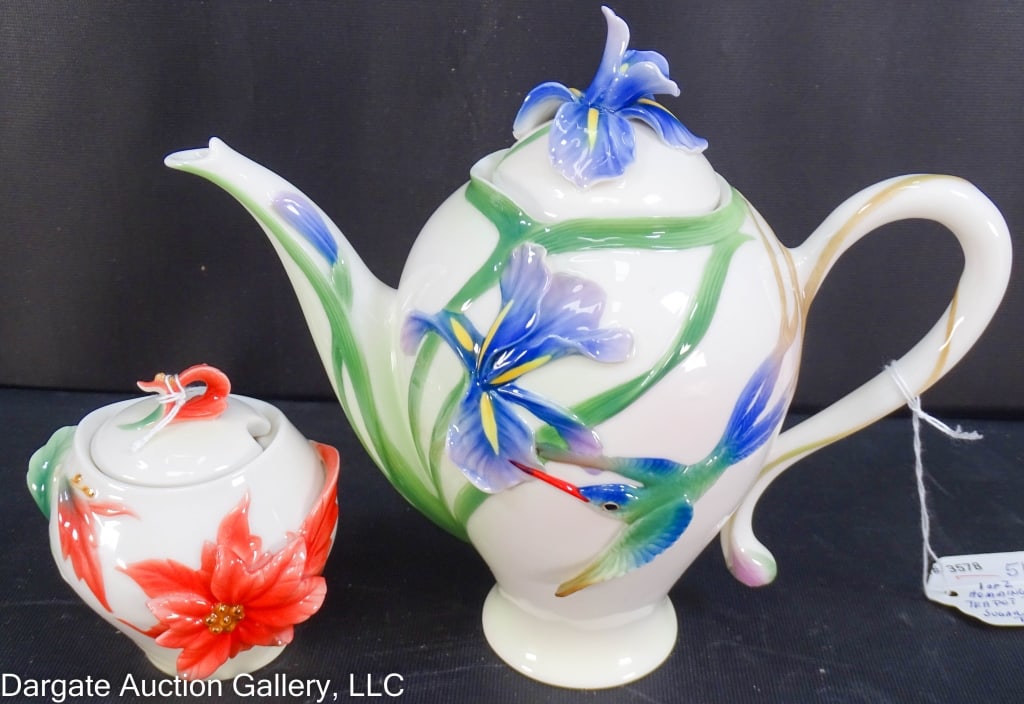 2pc FRANZ PORCELAIN LOT TEAPOT & SUGAR JAR: The teapot is a sculptured hummingbird and iris design with lid (6.25"H x 8"W); the sugar jar has a poinsettia, and also has a lid (3.25"H x 3.25"W)