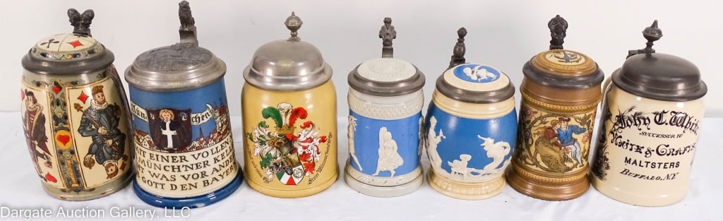 7 GERMAN BEER STEINS W/PEWTER LIDS: Seven Mettlach German beer steins with pewter lids, including one with a playing card design, two with a white relief on a blue background, and one by John White. Largest is 6.5" x 3.5", smallest is 5