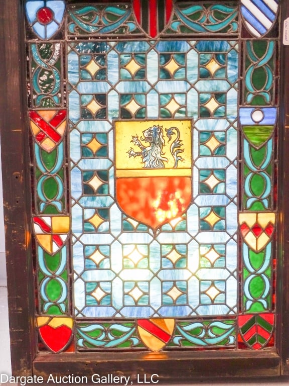 ENGLISH TUDOR STYLE STAINGLASS WINDOW: Nice stain glass window in English Tudor style with a large shield with a lion in the center. Ten small shields around the edges. Blues/greens/reds/white. Nice wooden frame. Frame 23.75" x 32.5" x 1.7