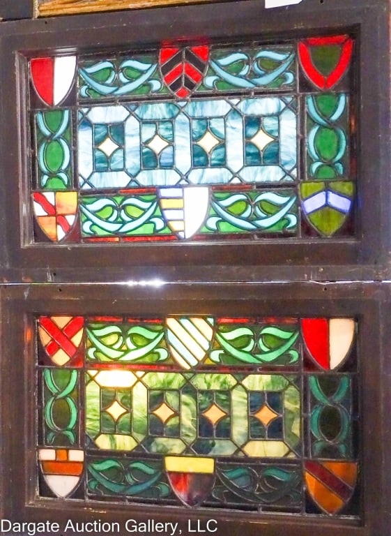PAIR ENGLISH TUDOR STYLE STAINGLASS WINDOW: Nice pair stain glass windows, English Tudor style. 6 shields around the edges, shades of blues, greens, amber, white, reds. Heavy original frames. Frame size 16" x 24" X 1.75" thick. Glass size 20" x