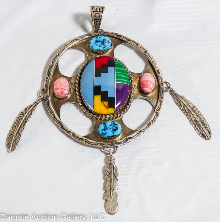 ZUNI STERLING SILVER INLAID PENDANT: Native American Zuni Sterling Silver pendant. Oval shaped pendant in a large central inlaid oval pattern, and stones on the top, bottom, left and right, including turquoise. Bail at top, and feathers 