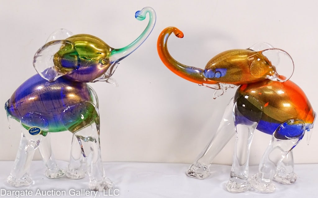 PAIR MURANO ART GLASS ELEPHANT MULTICOLOR GOLD: Pair art glass Murano Italy elephants, multicolored bodies with gold flecks, clear glass legs. Both with original paper tags. / Measures: 11.25"H x 1.5" W x 10"L / Provenance: From the descendants of 