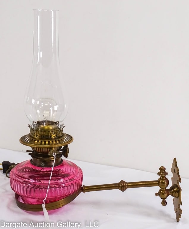 ANTIQUE CRANBERRY SWIVAL ARM WALL LAMP: Circa mid 19th Century cut crystal swivel arm wall lamp with heavy brass mount, professionally electrified, duplex burner / Measures: 16"H x 14"D x 5.75"W