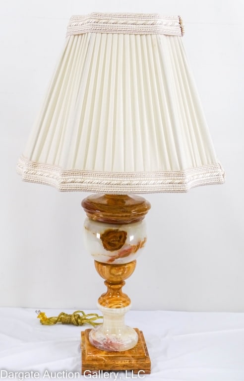 TURNED BUTTERSCOTCH/WHITE ONYX TABLE LAMP: A nicely veined butterscotch/white onyx table lamp, square base with a turned column, with a pleated silk shade. Lamp alone is 18.25" tall, base is 6.25" x 6.25". With the shade, 31.5" tall. / Provena