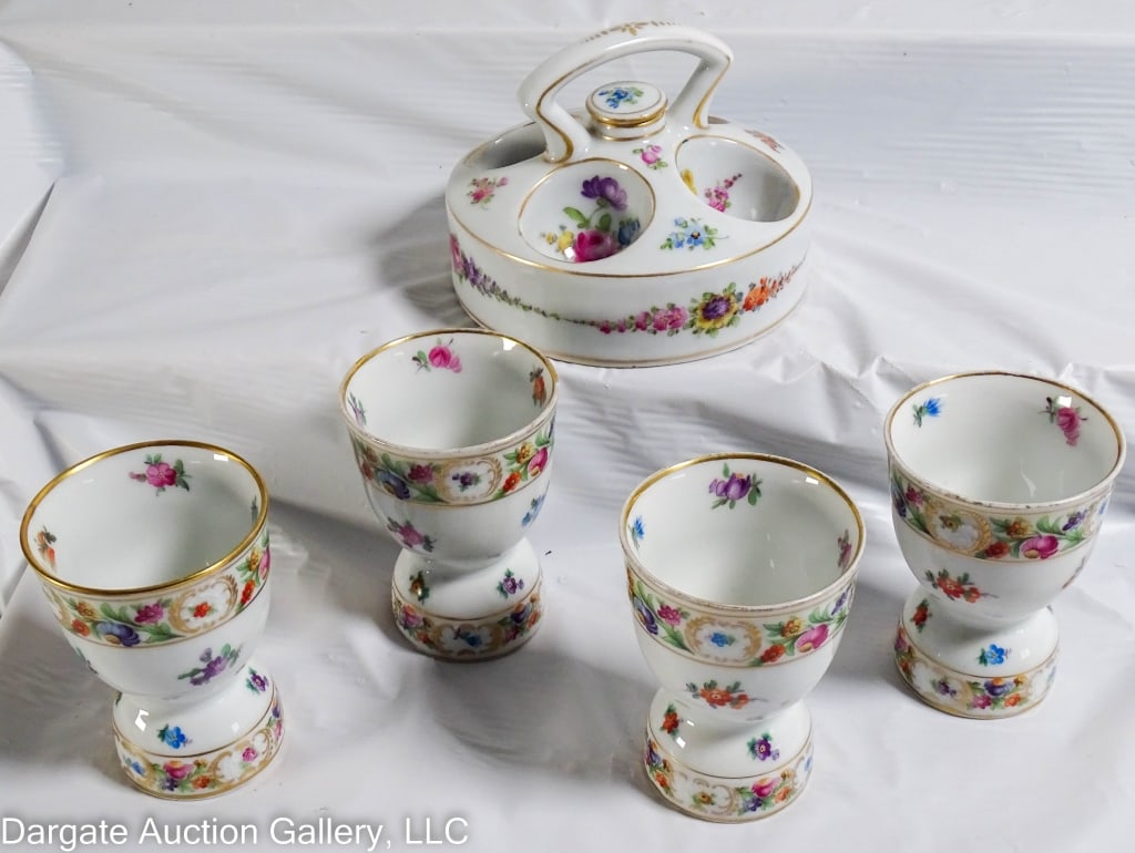 DRESDEN EGG WARMER AND 4 DRESDEN EGG CUPS: A Dresden egg warmer retailed by Ryrle Bros LTD, Toronto; together with 4 Dresden egg cups by Schumann Bavaria. Marked [Dresden/Schumann Bavaria]. / Measures: Egg warmer: 3.75" H x 5.5" W / Provenance