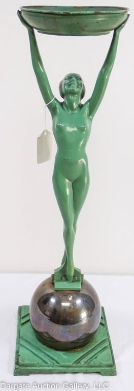 FRANKART ART DECO FEMALE NUDE ON SPHERE ASHTRAY: A Frankart ashtray of a nude woman standing on a sphere, holding a round bowl above her head. Made of spelter, brass, and steel. Signed on base Frankart pat. Des 80059. Base is 7.25" square, bowl is 6