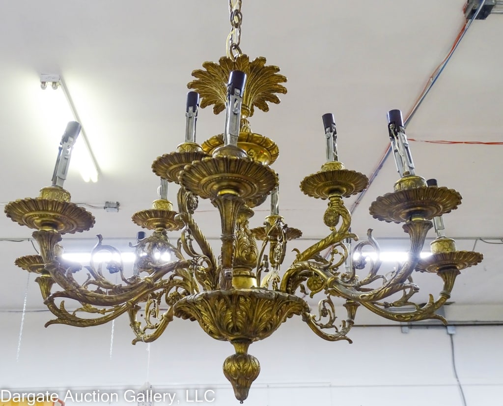 ORNATE CAST BRASS 12 LIGHT HANGING CHANDELIER: Very nice cast Brass hanging chandelier. 3 ornate arms with 3 lights, 12 lights total. Mark made in Spain. This would take 97 glass prisims. 27" diameter / Measures: 22"H / Provenance: From the descen