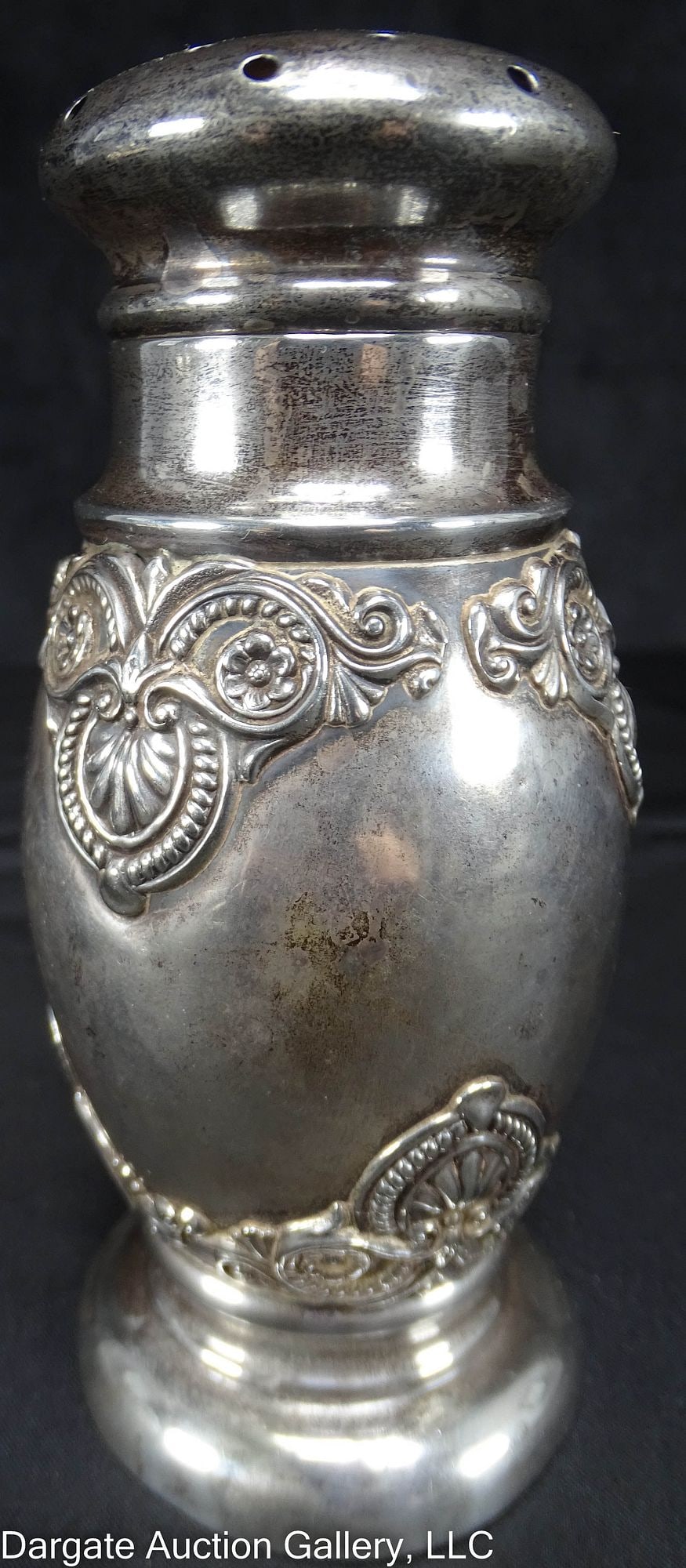 VICTORIAN STERLING MUFFINEER SUGAR SHAKER: A Victorian Sterling sugar muffineer in a shell and scroll design; marked [Sterling] / Weight: Total Gross Weight: 125.3g / Measurements: 5"H x 2.25" diameter / Condition: Base has a slight bend/ ONLI