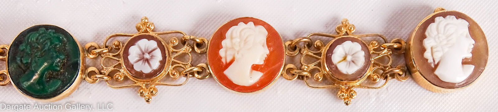 14K YELLOW GOLD CAMEO BRACELET: Hardstone and shell cameo bracelet; 6 portrait cameos separated by small floral cameos set in filigree gold with a box clasp; Cameos are carved malachite, abalone, coral, and others; the mark is worn,