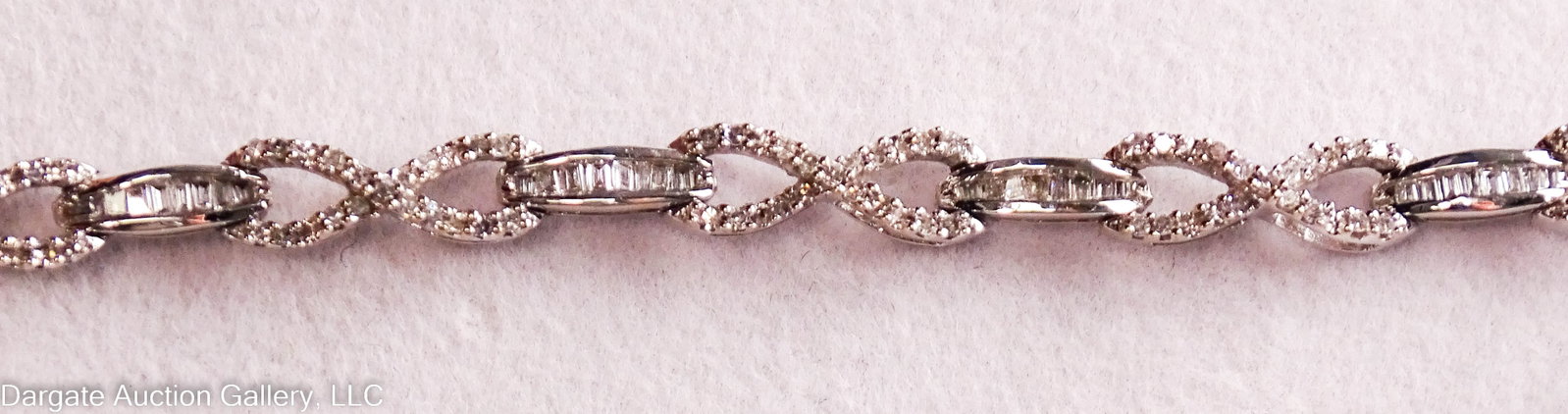 10k WHITE GOLD DIAMOND TENNIS BRACELET: 10k white gold infinity symbol and bar links set with round and baguette diamonds with box clasp; marked [10K JWBR] / Weight: Total Gross Weight: 8.1g / Measurements: 6.75"L / ONLINE PAY MSG ****