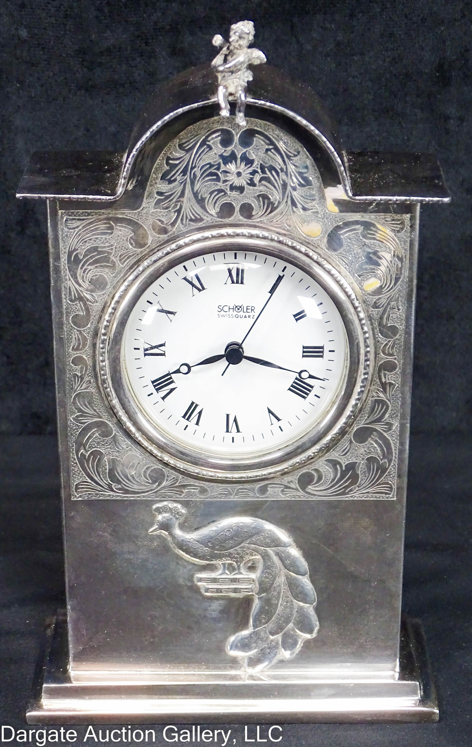 CAMUSSO STERLING CLOCK SCHOLER MOVEMENT: A Sterling desk clock by Camusso, winged cupid finial, peacock front design with incides scrollwork around the face of the clock; marked Scholer, Swiss Quartz; Marked on clock base and back [Sterling
