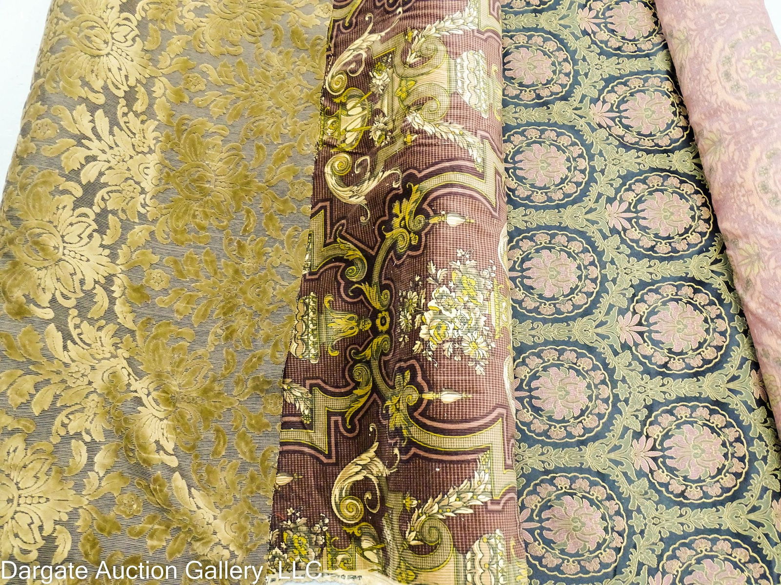 3 ROLLS HEAVY WEIGHT UPHOLSTERY FABRIC: Three rolls heavyweight upholstery fabric including: (1) from P. Kauffman, 17 yards of burgundy floral design; (1) 15 yards of an unmarked green and burgundy damask; (1) 8 yards of an unmarked black a