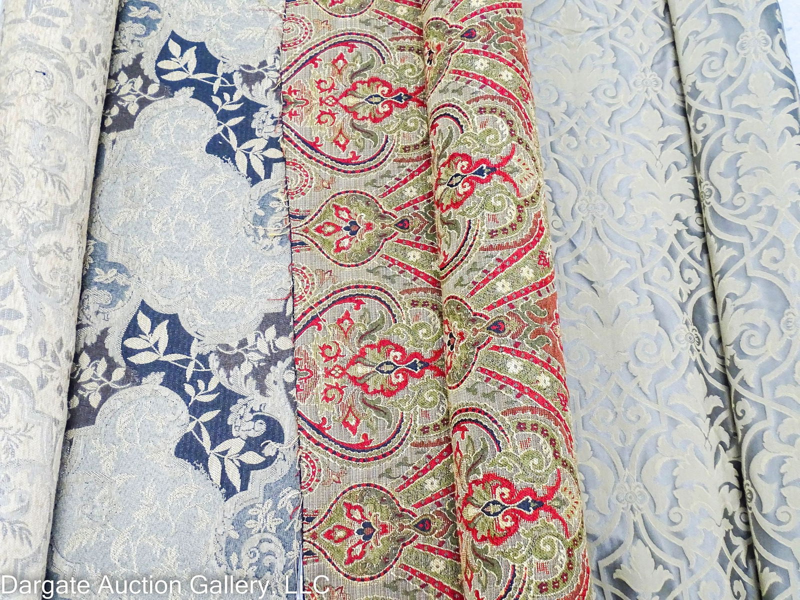 3 ROLLS HEAVY WEIGHT UPHOLSTERY FABRIC: Three rolls of heavy weight upholstery fabric, all unsigned; includes: (1) 6 yards of black/brown gold vine and floral fabric; (1) 4 yards of railroaded olive green/gold damask; and (1) 4 yards of gre