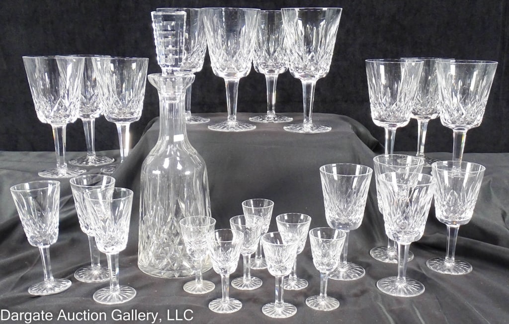 25 PIECES WATERFORD LISMORE STEMS AND DECANTER: Decanter: 13.5" with stopper. (10) 6.75" tall water glasses. (4) 5.5" tall wines. (3) 5" tall cocktails. (7) 3.5" tall cordials. / Provenance: From the estate of Royce Walters, Indiana PA / Condition: