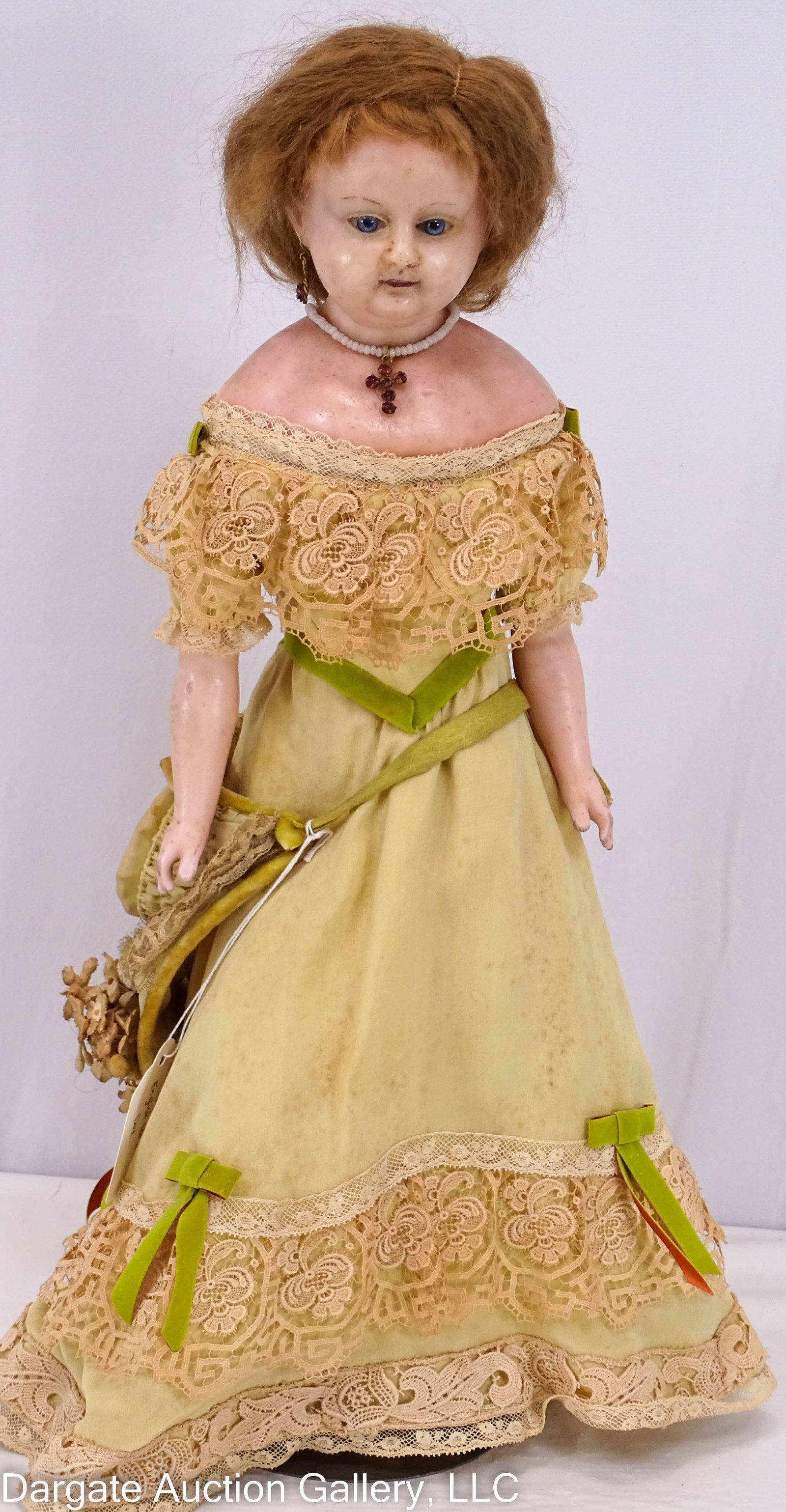 ENGLISH 16" POURED WAX DOLL: A 16” poured wax should head doll with plump facial modeling, light blue glass eyes, brown mohair wig, stuffed muslin body, poured wax arms and legs with cast shoes; She wear a light green dress