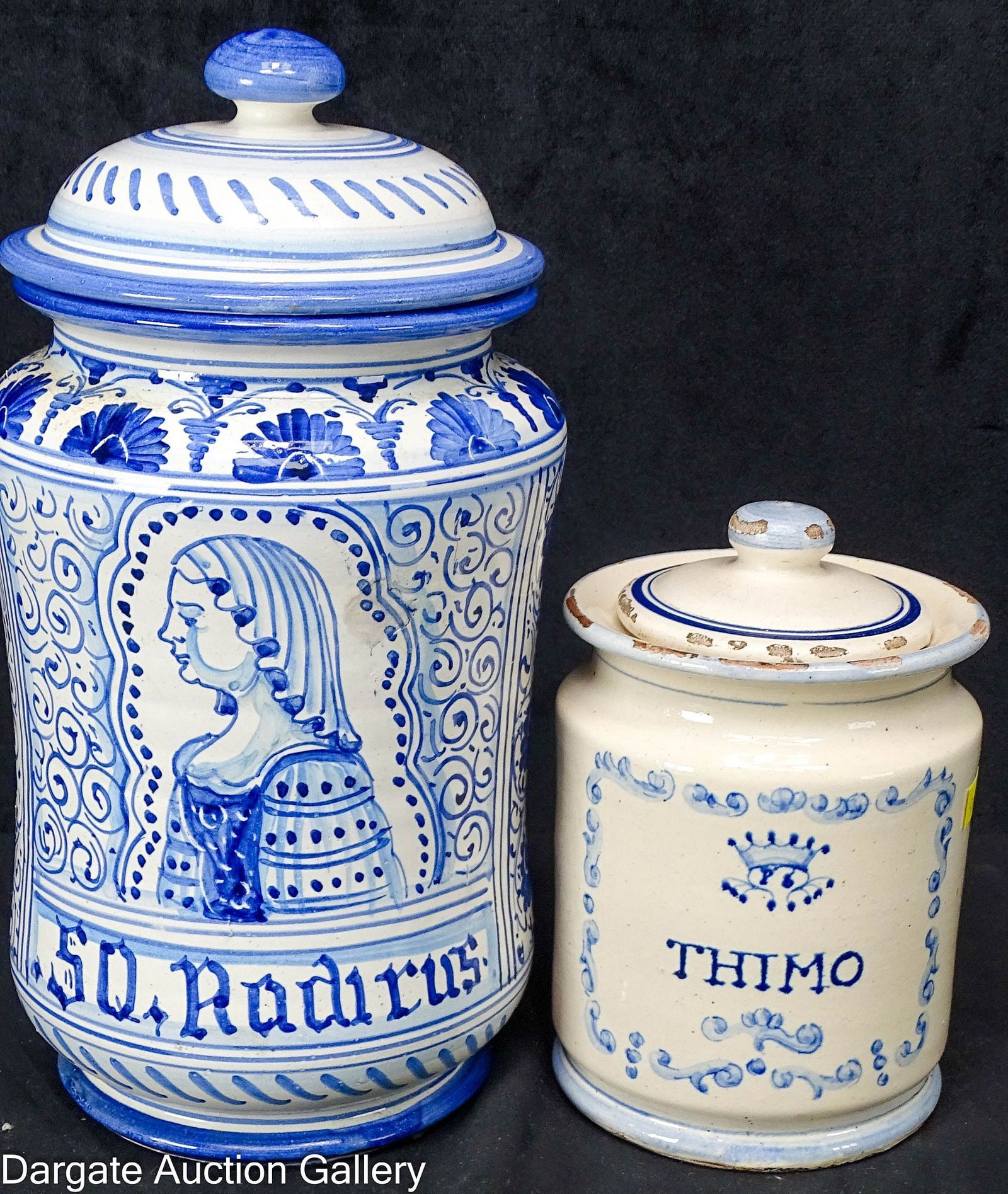 (2) ITALIAN POTTERY ALBARRELLO APOTHECARY JARS: (2) Apothecary jars with lids, both with blue hand painted decoration; one with scrolls and a crown over the word [THIMO] (6.5"H x 4.5"D]; the other ornately decorated with a woman's por