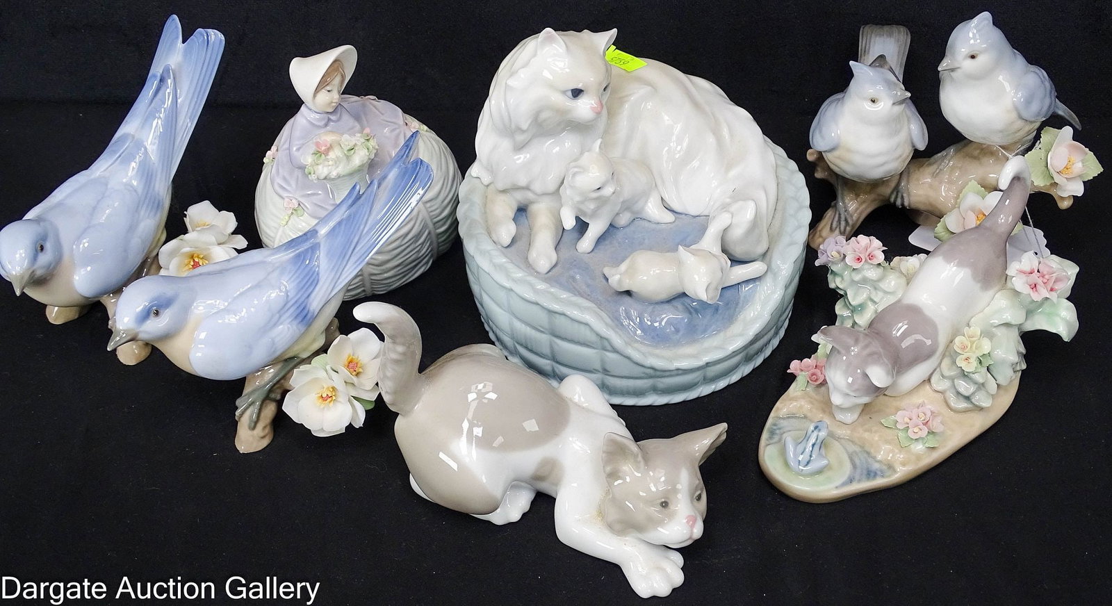 (7) ASSORTED LLADRO FIGURINES: The set features 3 cats in a basket with chips to 2 of the mother cat's ears; a cat with flowers and frogs showing losses to the flowers; and a crouching cat. Also included are a lady with a flowe
