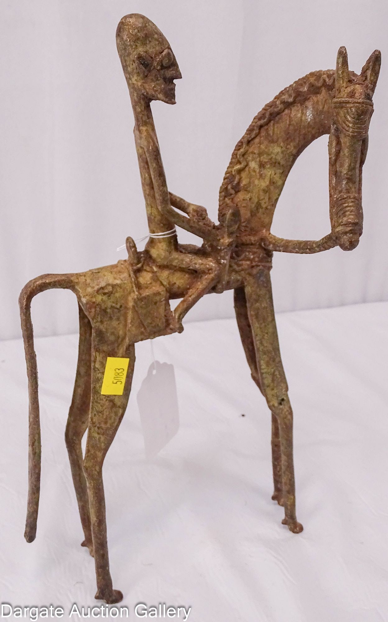 STYLIZED DOGON BRASS MAN ON HORSEBACK: Stylized brass sculpture depicting a Hogon spiritual leader mounted on horseback in the elongated Sudanic style popular in the Sahel region. Horses were historically rare and costly symbols of status 