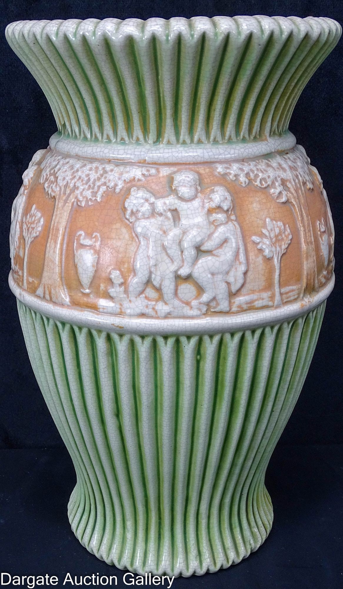 ROSEVILLE POTTERY DONATELLO VASE: Roseville pottery vase in their Donatello Pattern 1915-1916; This has a creme and green fluted body with a band of cream colored putti and trees against a brown background; Measures: 12"H x 7&quo