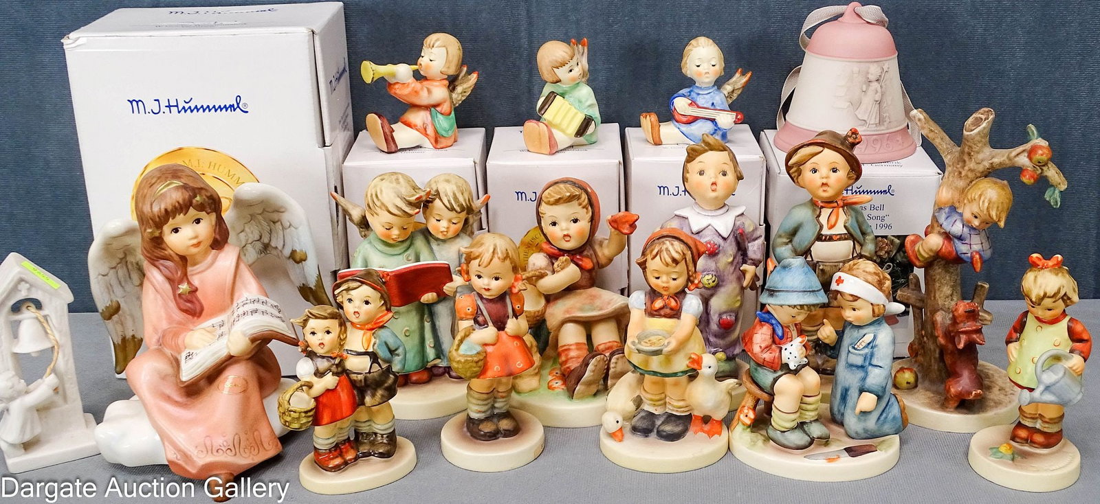 16 ASSORTED GOEBEL PORCELAIN FIGURINES and BELL: 16 Goebel porcelain figurines and a bell, including Christmas and Hummel children; Different marks from different eras, including West Germany marks; Measures: range in size from 4"H to 7.5"