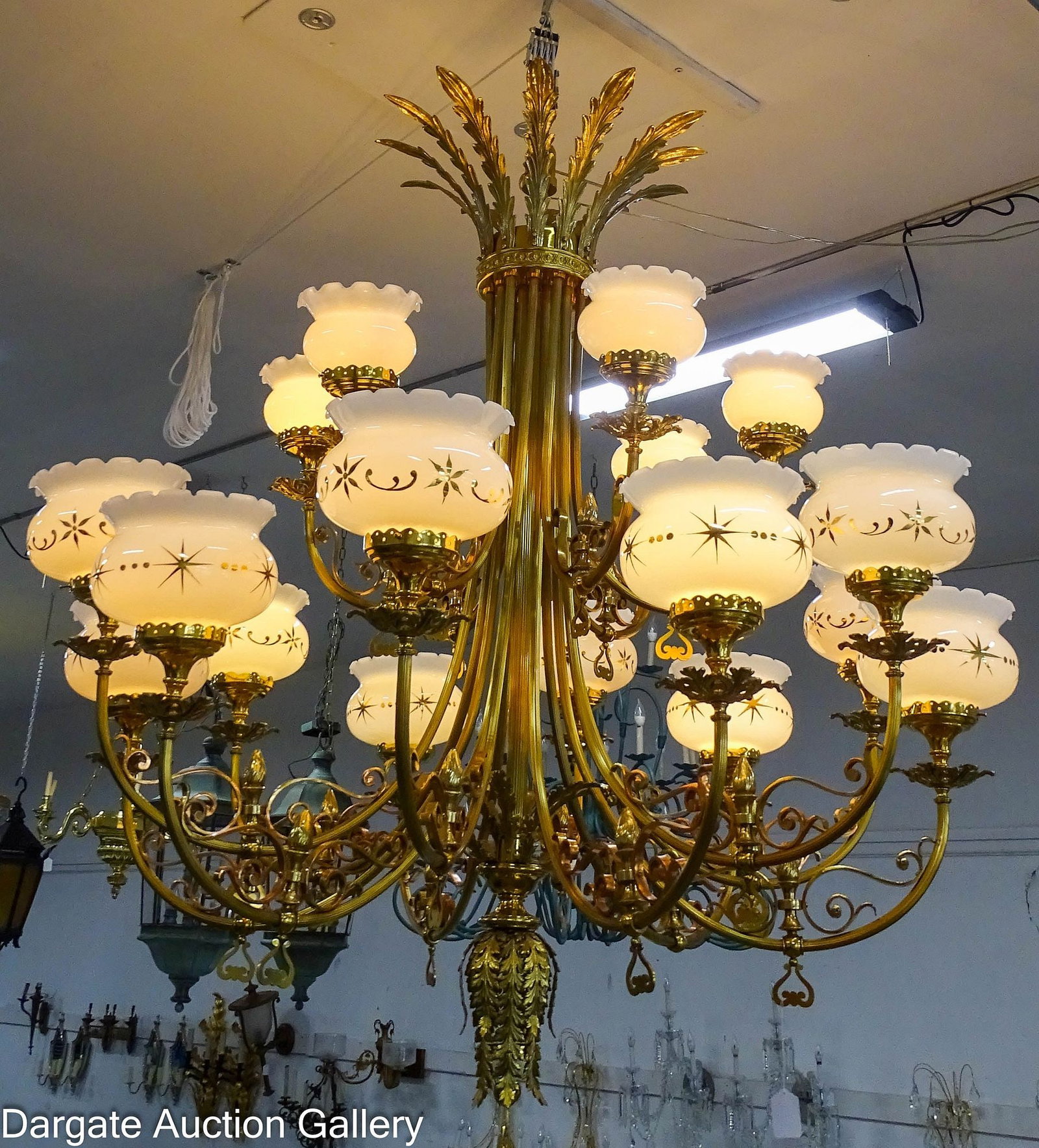 EARLY 19tH CENTURY ART NOUVEAU MONUMENTAL BRASS CHANDELIER: A monumental brass chandelier with copper accents, 18 arms each with a milk glass shade; 12 lower arms with scrolls of copper and brass acorn finials, the 6 upper arms, smaller, with scrolls of
