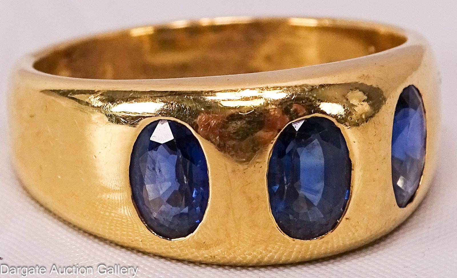 18k YELLOW GOLD SAPPHIRE RING: 18k yellow gold ring set with 3 oval sapphires (7mm x 5mm), marked [18k]; Measures: Size - 12, Total gross weight - 15.0g