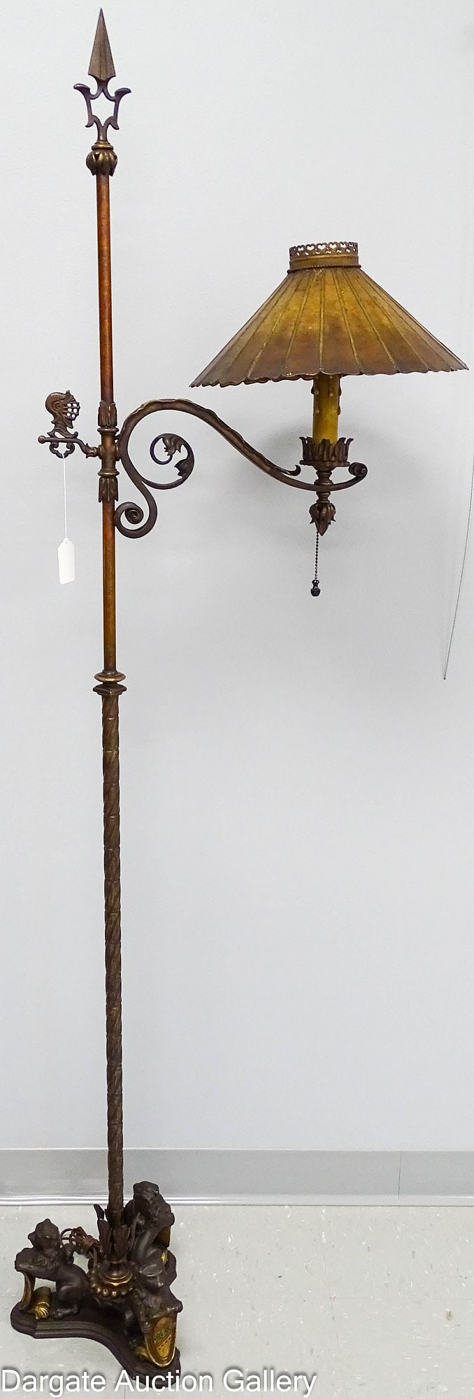 CAST IRON CREST LAMP COMPANY FLOOR LAMP: Early 20th Century cast iron floor lamp marked [CREST 664]; the design of this lamp is attributed to Oscar Bach; Base is triangular with 3 rampart lions holding multi-colored heraldic crest shields; t