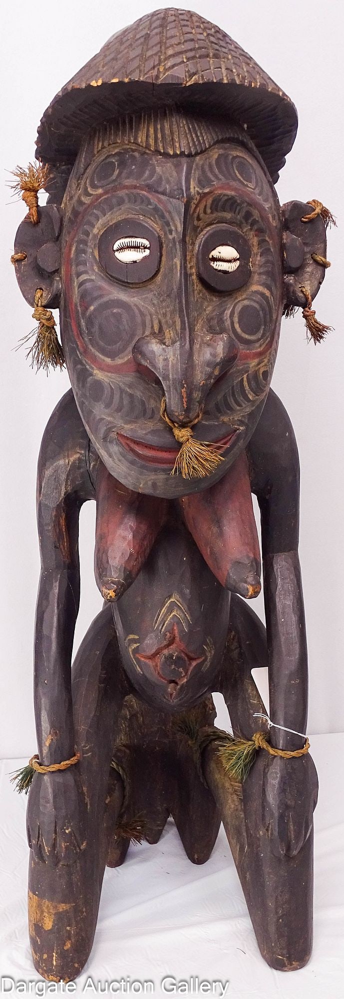 PAPUA NEW GUINEA SEPIK RIVER CARVED ANCESTOR WITH CROCODILE: A carved ancestor figure from the Sepik River region of Papua New Guinea, specifically associated with the Iatmul culture. These figures served as dwelling places for the soul and were kept in clan ho