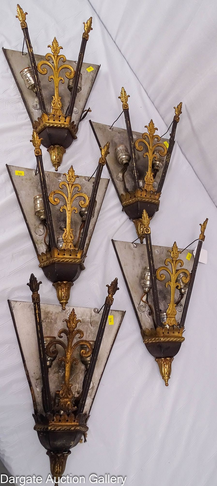 (5) MATCHING ART DECO STYLE WALL SCONCES: Set of 5 wall sconces from a 1930's motion picture theater; cast brass and tin construction; features a central fleur-de-lis motif with "winged" spearpoint finials; each has standard lig