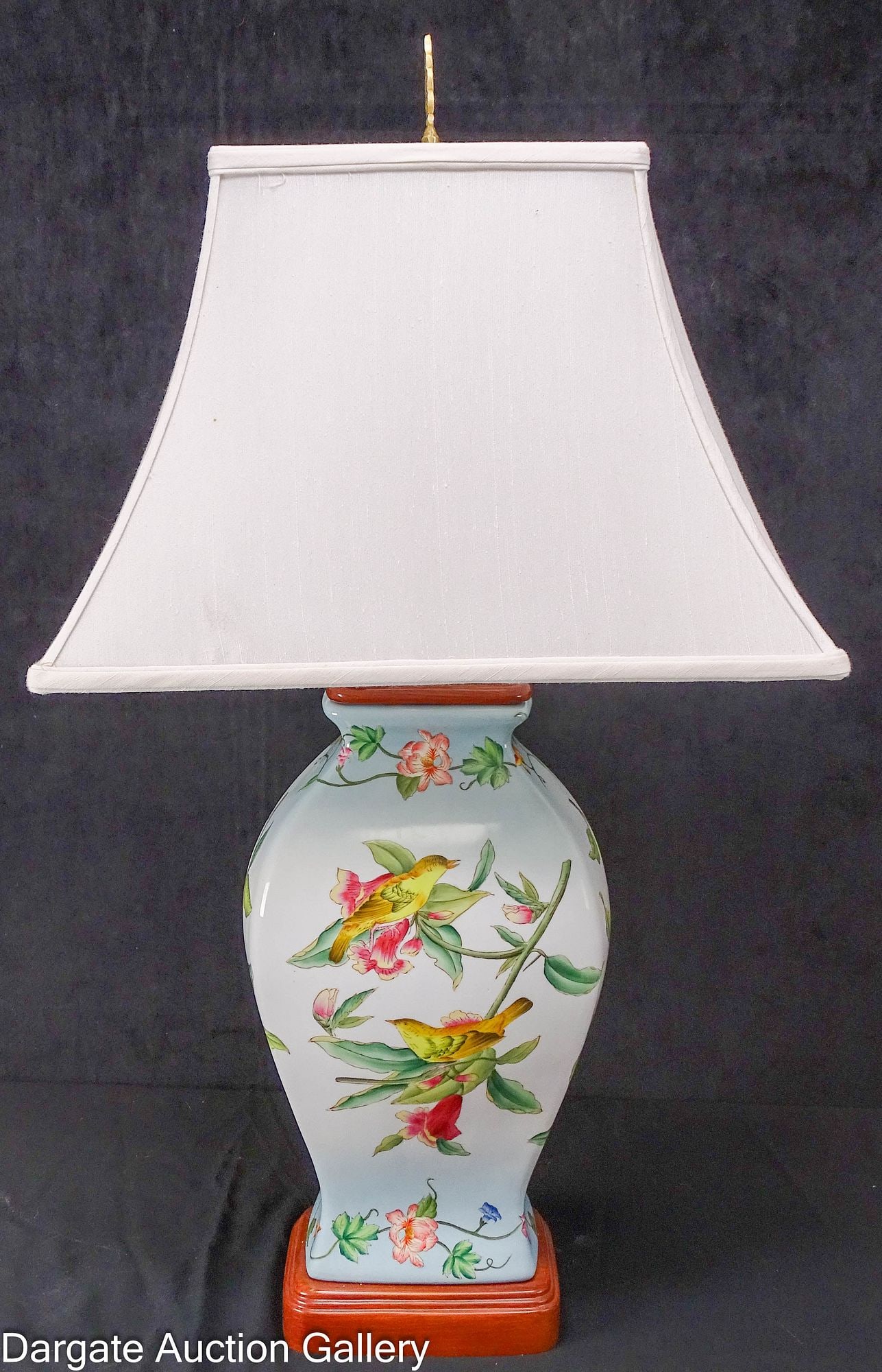 HAND-PAINTED LAMP WITH BIRDS AND FLOWERS: A hand-painted porcelain lamp on a blue gradient background with tropical flowers and yellow birds. Base and lamp top are porcelain painted to simulate wood, rectangular base and shade; Measures: Lamp
