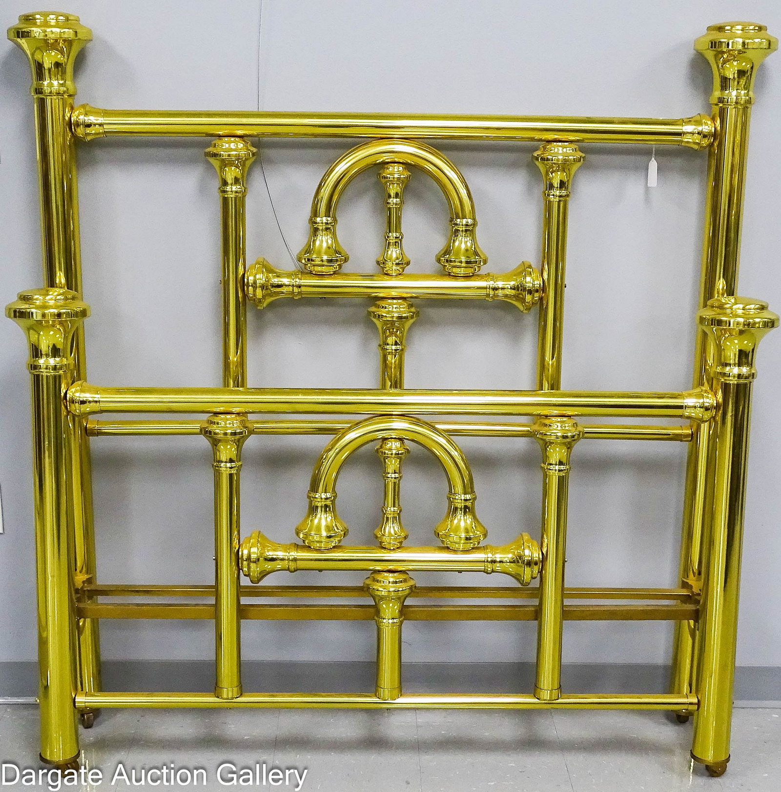 ANTIQUE BRASS BED RESTORED AND POLISHED: A full-size double brass bed featuring tubular construction topped with large 6" diameter finial caps and original cast iron side rails. This piece has been professionally restored and polished b