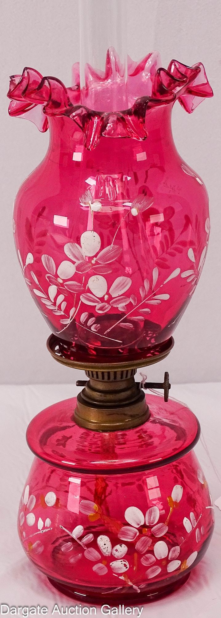 VICTORIAN CRANBERRY GLASS MINIATURE OIL LAMP: Cranberry glass oil lamp and matching ruffled top shade with enameled flowers, possibly European; burner marked [SPAN - BRENNER] and shade features a ground bottom / Dimensions: 9&quo