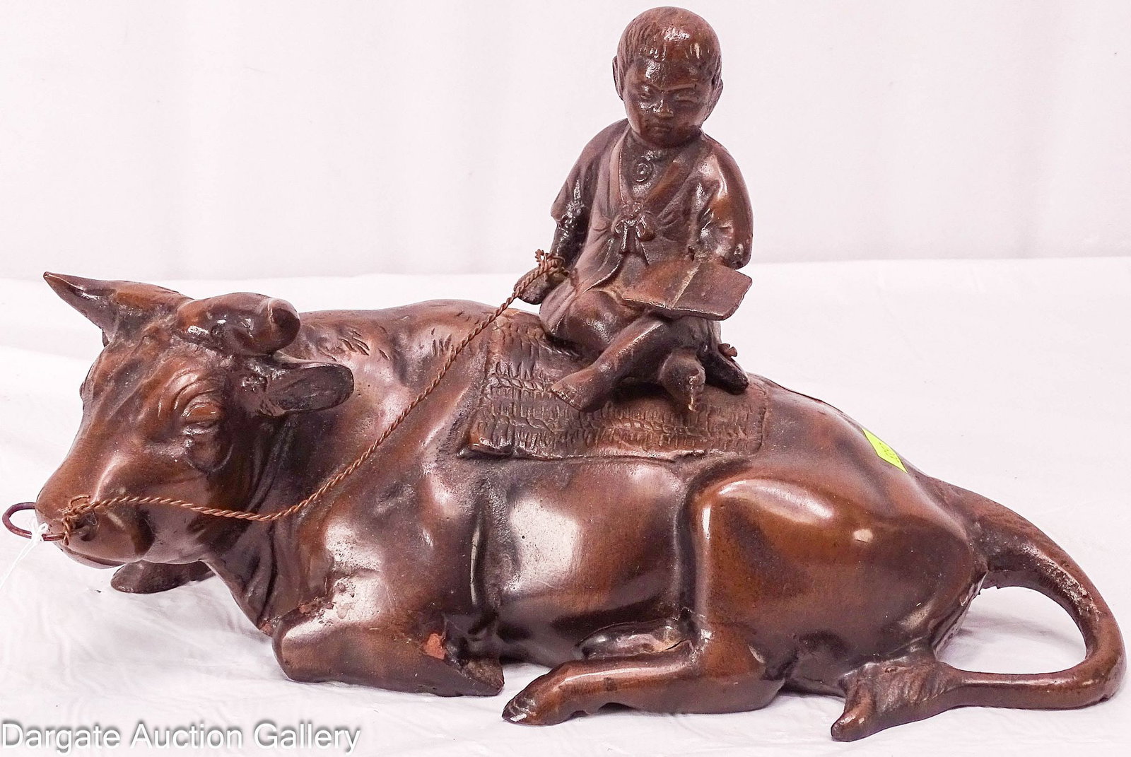 JAPANESE BRONZE SPELTER OKIMONO BOY ON A WATER BUFFALO: A contemporary casting of a young boy reading while resting on a water buffalo. This Japanese bronze spelter Okimono statue is based on a Meiji era original / Dimensions: 7.25" H