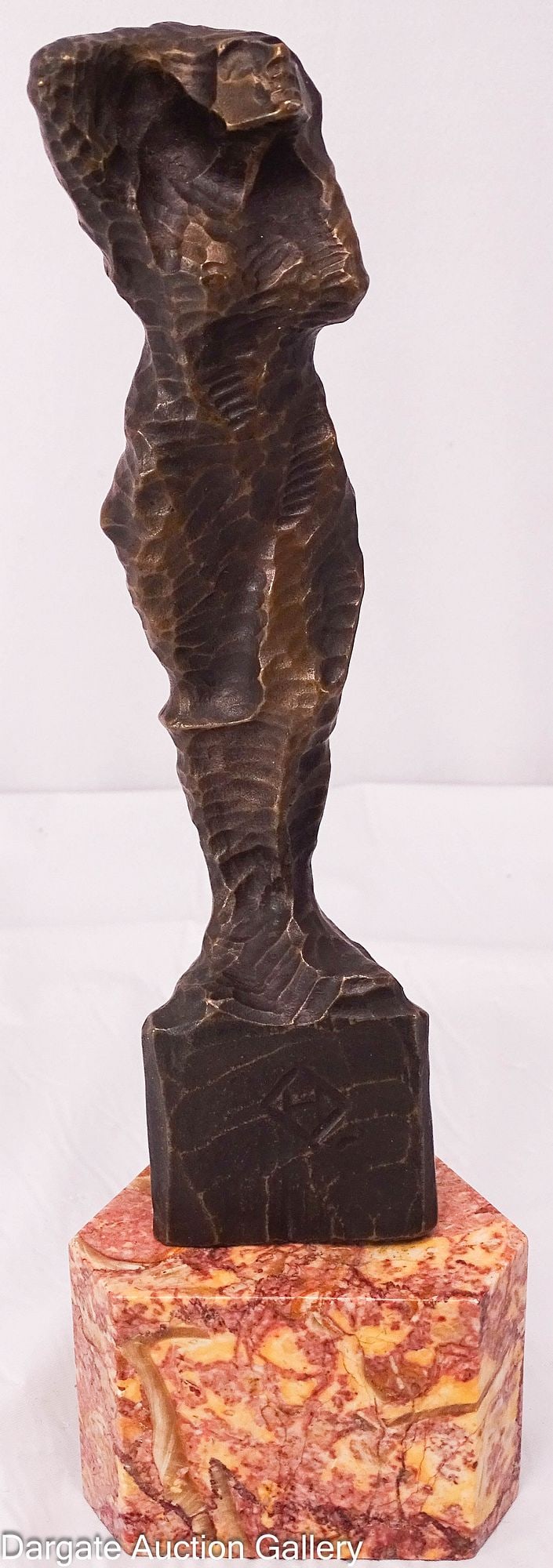 BRUTALIST BRONZE SCULPTURE OF A NUDE WOMAN: A bronze sculpture in the brutalist style, similar to the works of Heinrich Brockmeier, a nude woman, she stands a top a stone base, which may be Jasper. The bronze is separate from the base, and has 