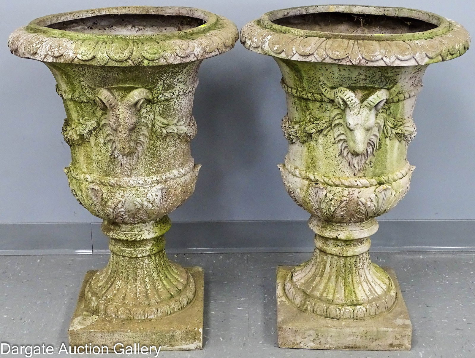 PAIR CLASSICAL URN FORM POLYSTYRENE PLANTERS: A pair of classical urn form polystyrene planters in a weathered stone finish, decorated with ram heads and swags; Measures: 30"H x 20" diameter; Condition: wear to finish, small rim cracks