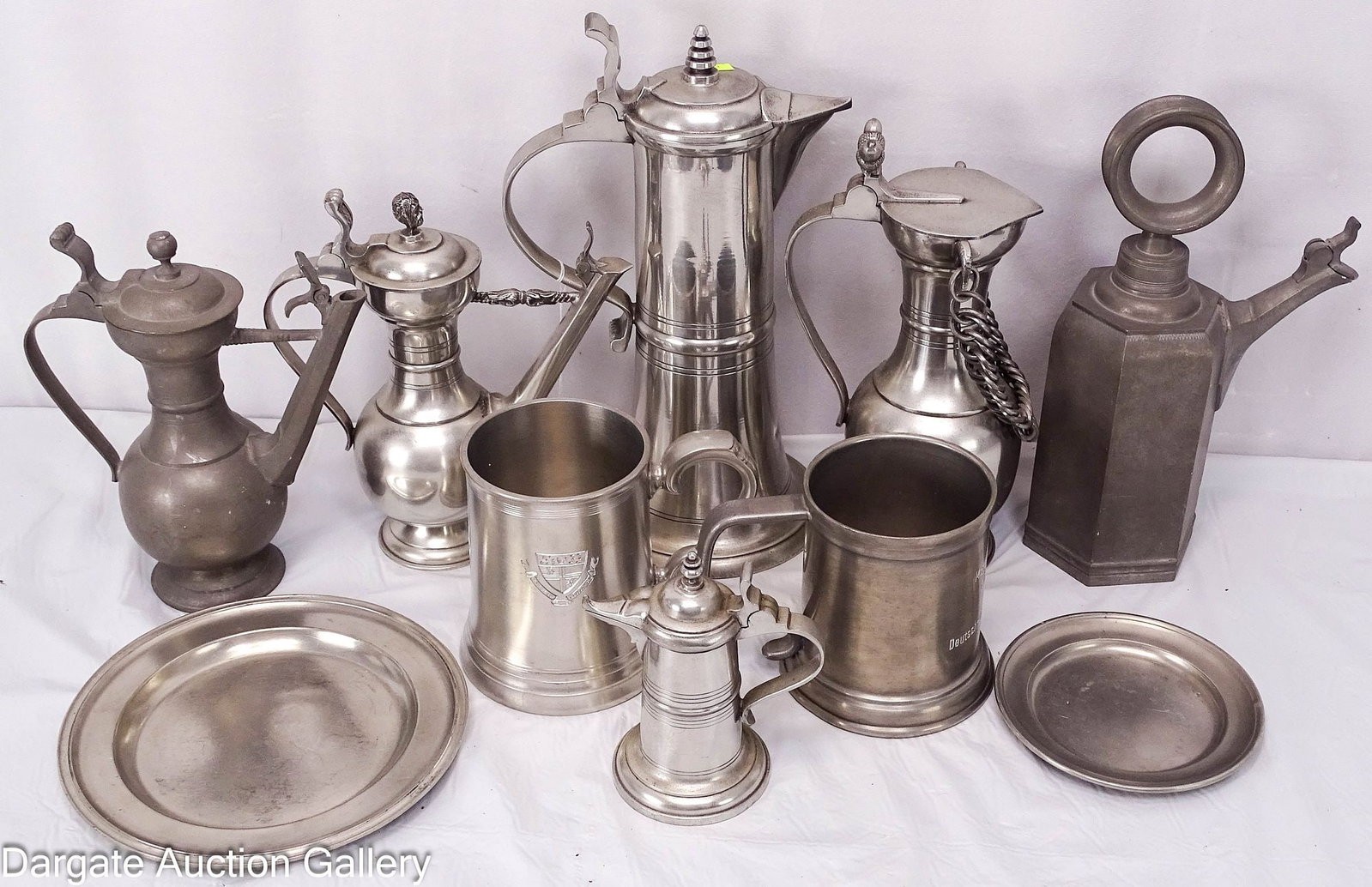 10pcs PEWTER incl STEINS & STEGKANNE WINE FLAGONS: This lot includes two steins inscribed to Bishop Brandt, one from his College Days in Rose, the other when he was a Monsignor. includes 6 wine ewers or flagons, 3 marked Brandt 1962 to signify wh