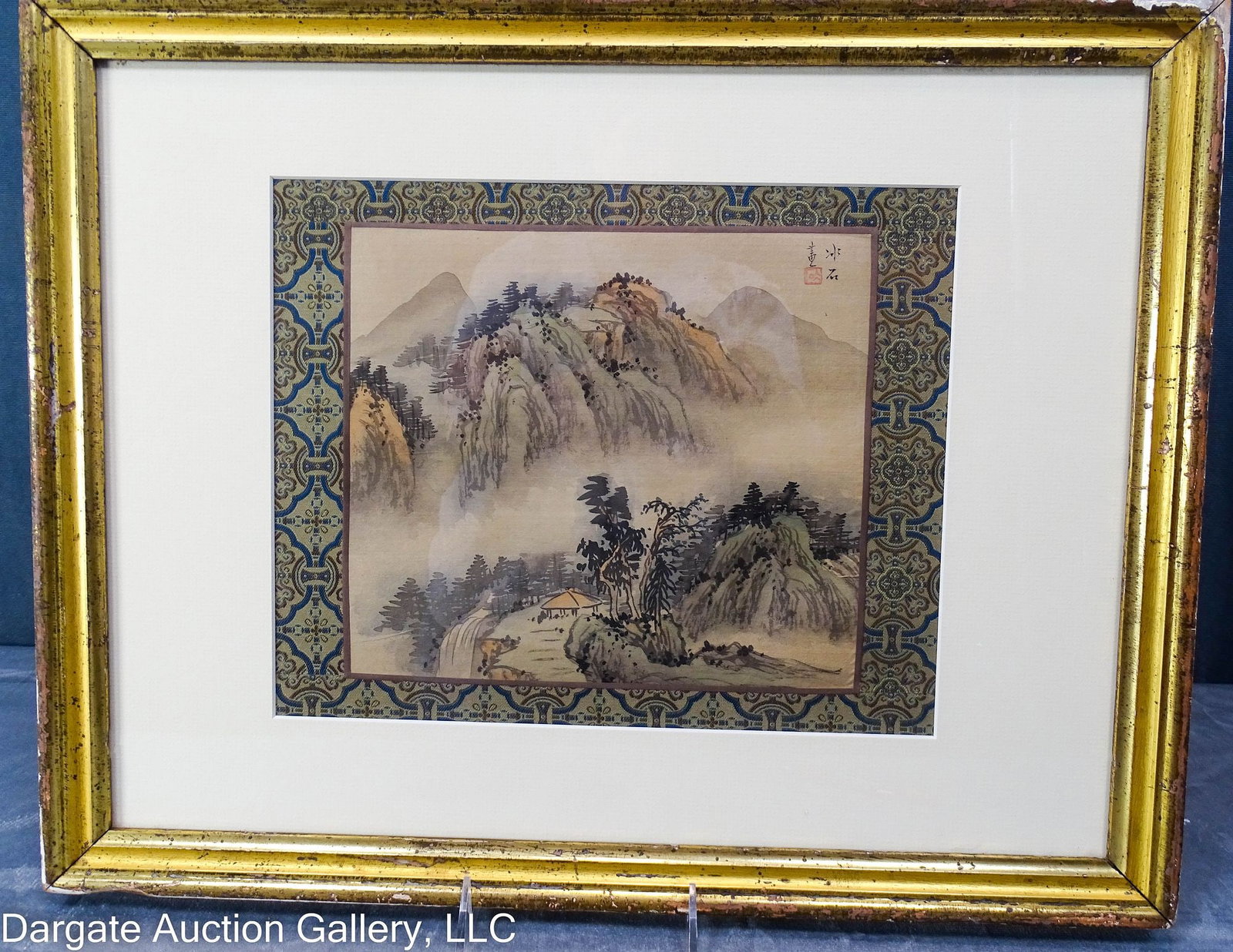 CHINESE SHAN SHUI LANDSCAPE: A Shan Shui style landscape painting on silk, featuring a misty mountain and waterfall. Mounted to a decorative silk border; set under glass in wood and gilt gesso frame / Visible Art Size: 12.75"