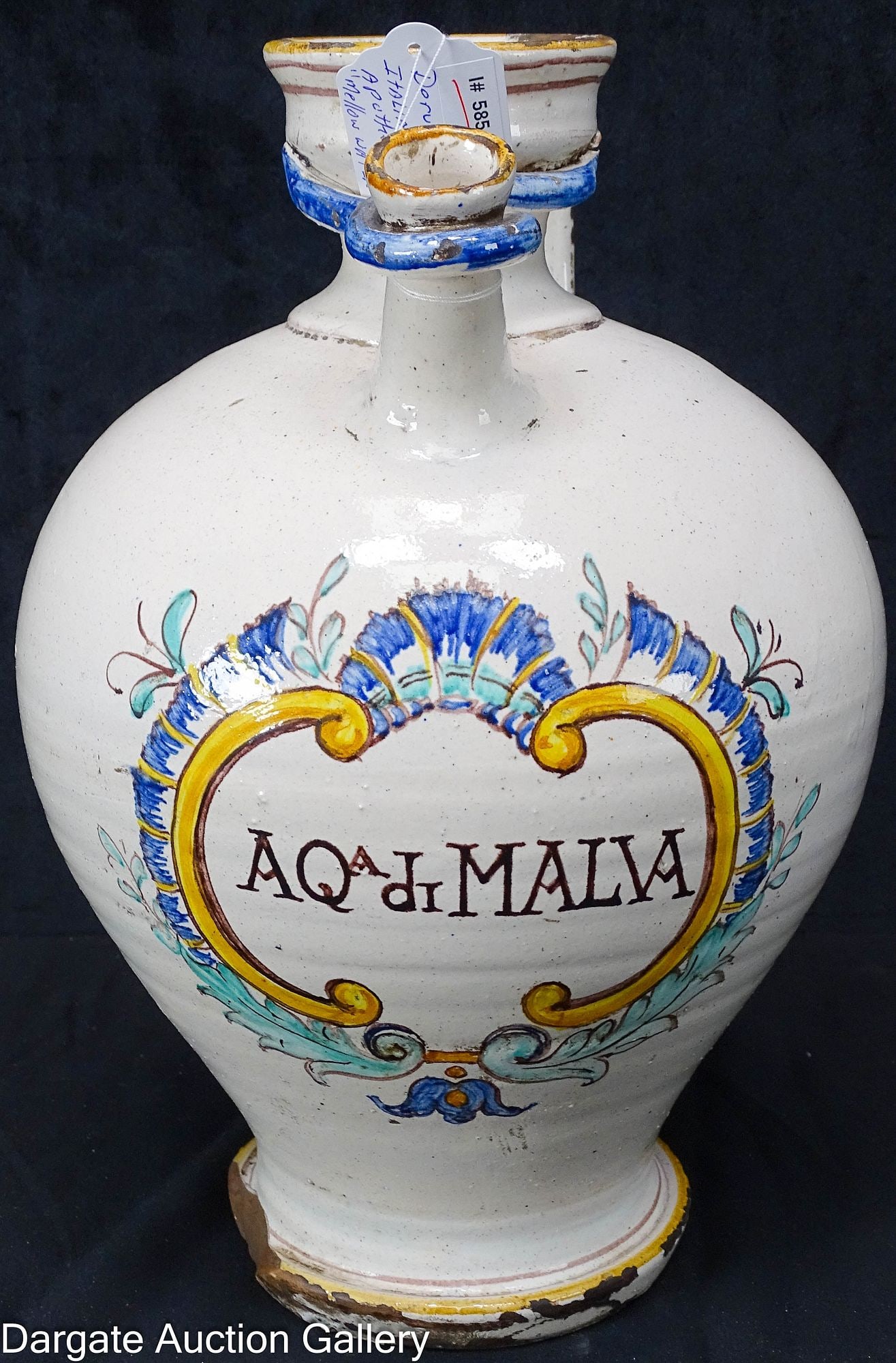 DERUTO STLE APOTHECARY JUG AQA DI MALVAY MALLOW WATER: An apothecary jug in the Deruto style with Mallow water written in Italian; Measures: 12.5"H x 9"W x 9"D; Condition: Large chip in base that has been smothered and darkened, Stress frac