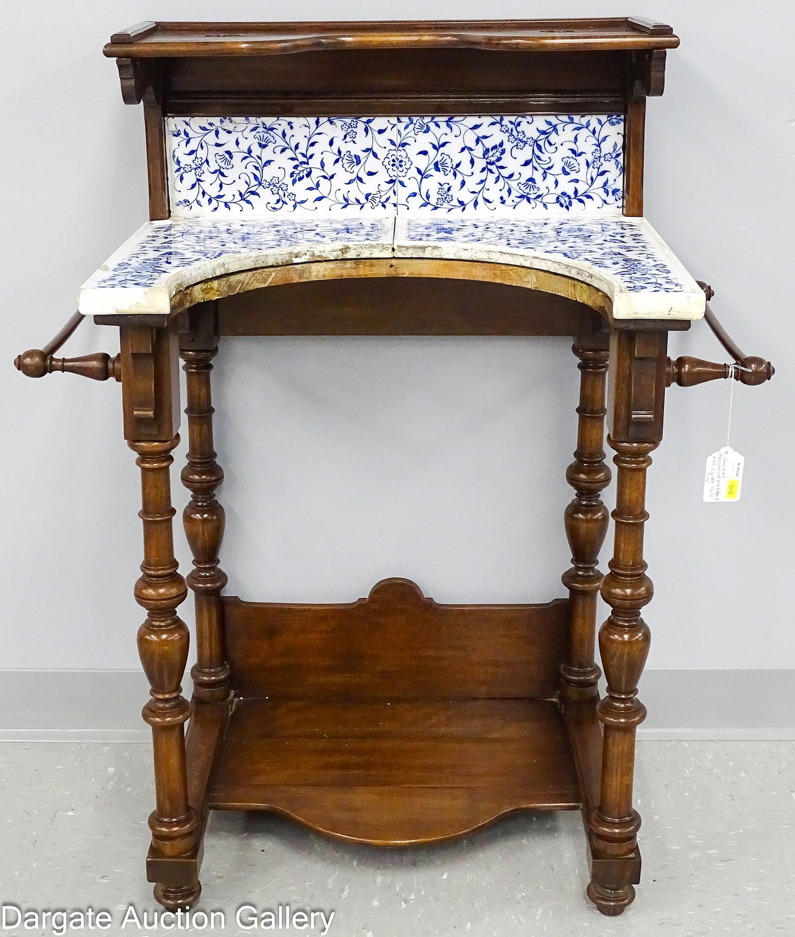 GERMAN HARDWOOD WASH STAND WITH DELFT STYLE TILE: A German hardwood wash stand featuring turned legs and a Delft blue-and-white style tile top and backsplash. This is an unusual and uncommon form of wash stand that originally included a curved front 