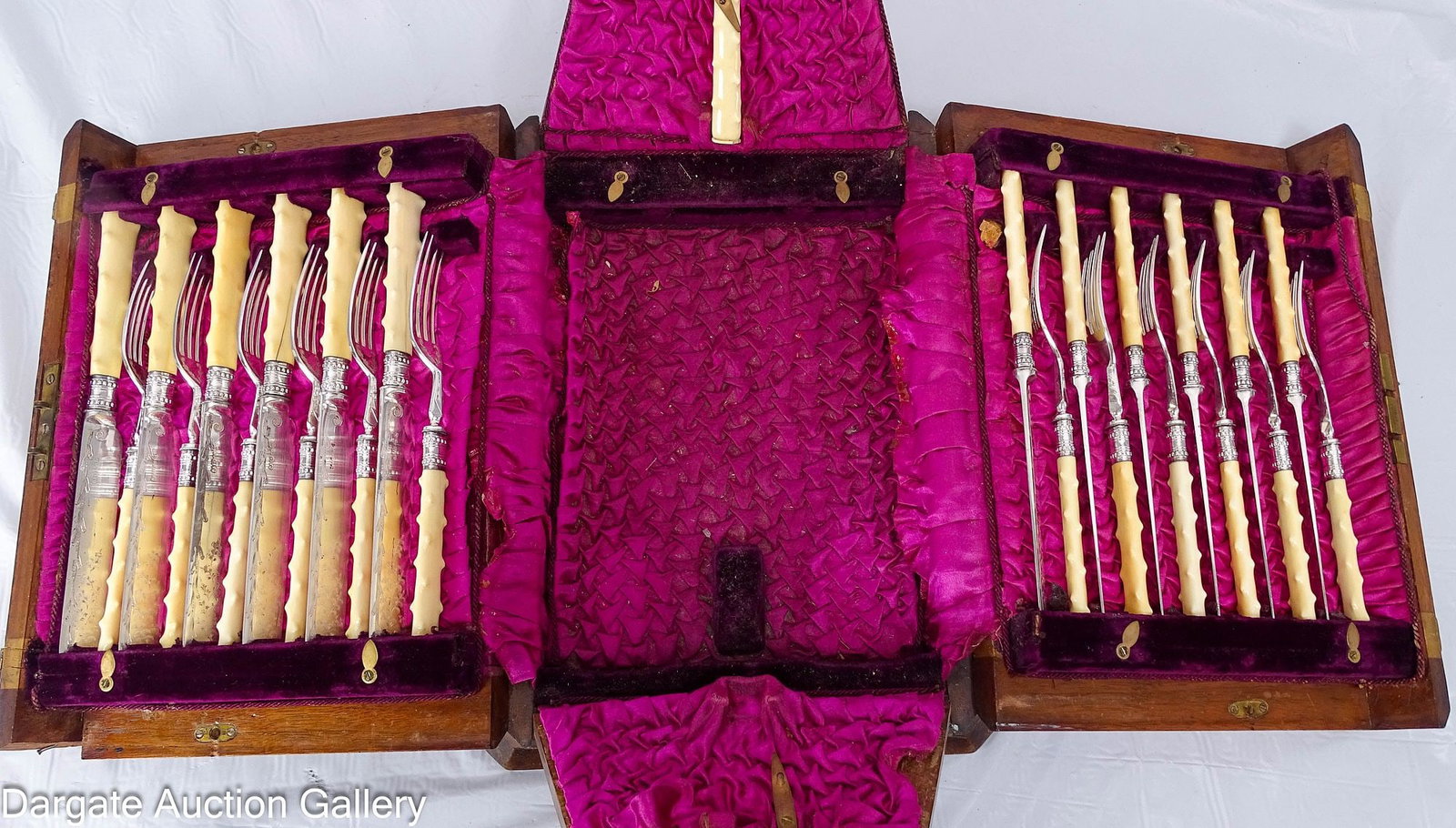 SILVER-PLATED FRUIT AND NUT SERVICE CANTEEN: A fruit and nut service for 12 in a mahogany and boxwood inlaid canteen with ebony string inlay. Includes 12 fruit knives and 12 fruit forks in a knotty bamboo pattern in celluloid, also includes a ma