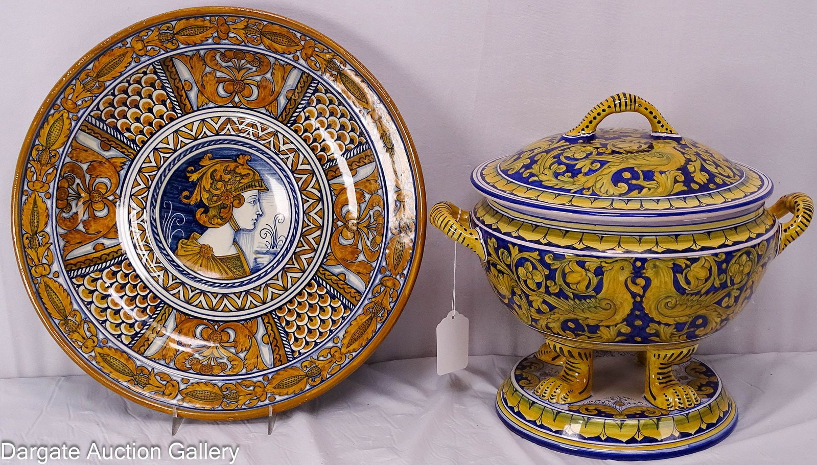 DERUTA POTTERY PORTRAIT PLATE AND FOOTED TUREEN: A 14" wall charger, in blue and golden brown glazes, with a soldiers portrait, scroll and foliate decoration. (Signed on back [Deruta[). Footed soup tureen done in blue and yellow glaze, decorate