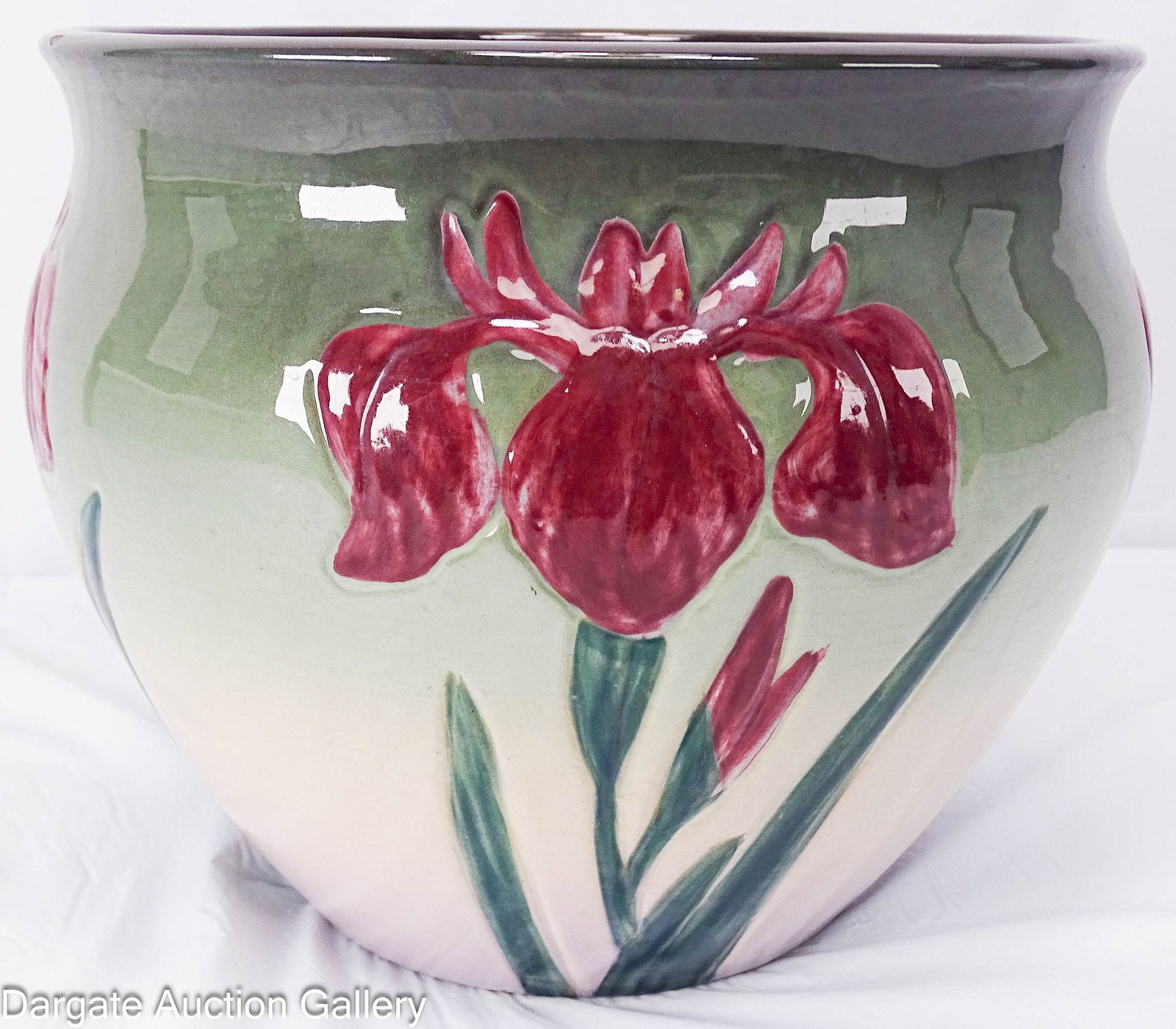 WELLER ETNA ART POTTERY JARDINIERE: Weller Ira Etna art pottery Jardiniere maroon colored iris blossom on a background of dark green on top fading to a light lilac purple glossy finish; Measures: 8.75"H x 10" diameter (to