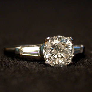 PLATINUM DIAMOND RING. The 1.20 ct. rou: PLATINUM DIAMOND RING. The 1.20 ct. round cut center stone is flanked by baguettes on both sides mounted in a platinum setting. Color: H. Clarity: I1. Condition: no visible defects.