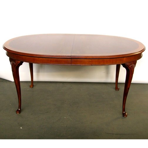 DREXEL QUEEN ANNE STYLE DINING TABLE. M: DREXEL QUEEN ANNE STYLE DINING TABLE. Mahogany with satinwood crossbanded oval top raised on shell carved cabriole legs with pad feet. Size: 29" H, 43" W, 64" L (add 20" each for two additional leaves